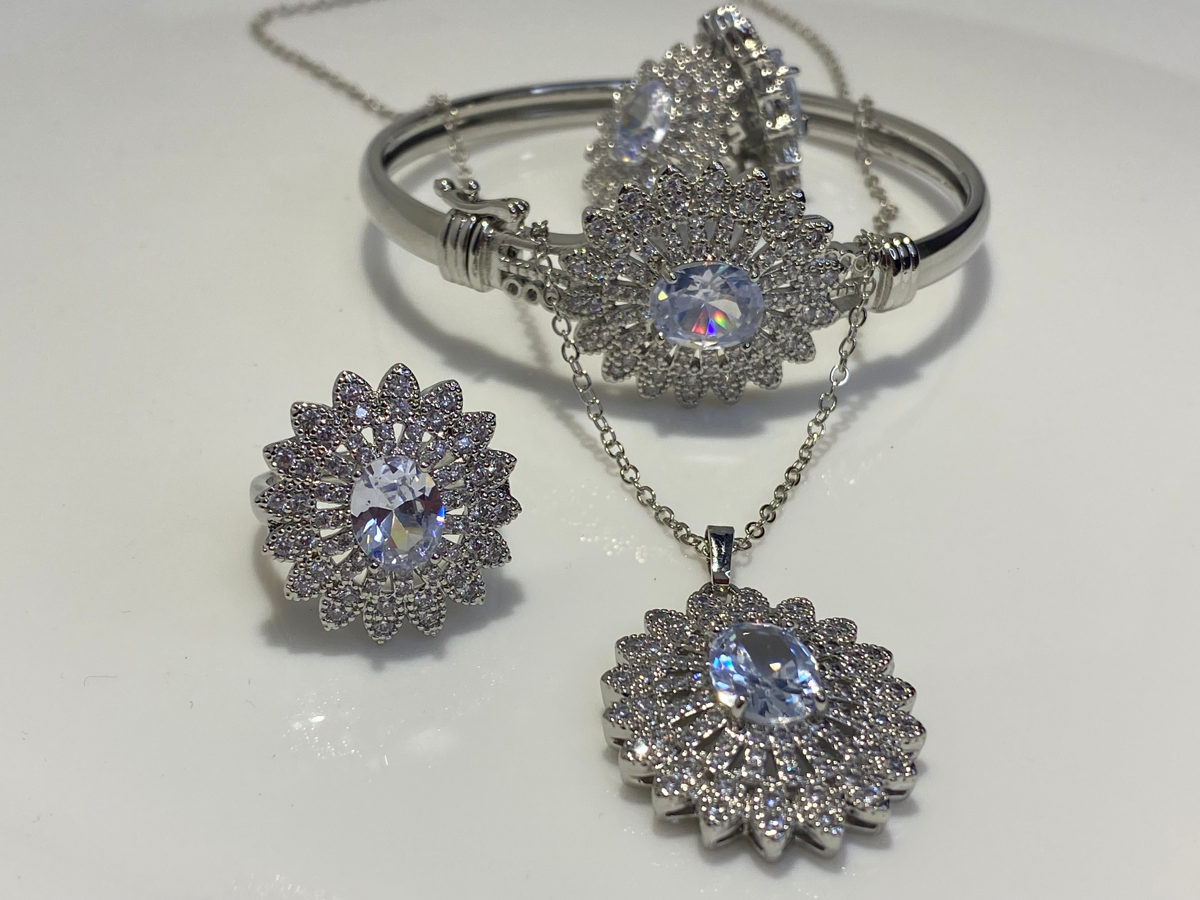 𝐒𝐢𝐥𝐯𝐞𝐫 𝐚𝐧𝐝 𝐠𝐨𝐥𝐝𝐞𝐧 𝐣𝐞𝐰𝐞𝐥𝐫𝐲 𝐬𝐞𝐭 𝐰𝐢𝐭𝐡 𝐚 𝐥𝐚𝐫𝐠𝐞 𝐜𝐞𝐧𝐭𝐫𝐚𝐥 𝐬𝐭𝐨𝐧𝐞 𝐬𝐮𝐫𝐫𝐨𝐮𝐧𝐝𝐞𝐝 𝐛𝐲 𝐬𝐦𝐚𝐥𝐥𝐞𝐫 𝐬𝐭𝐨𝐧𝐞𝐬.